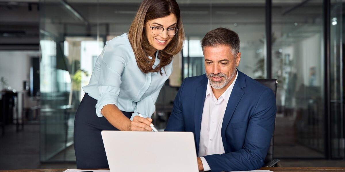 administrative professional with laptop showing professional development plan to boss